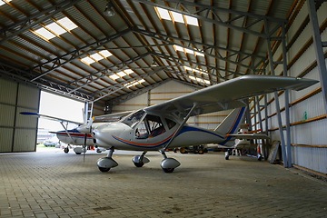 Image showing outdoor shot of small plane standing in shed