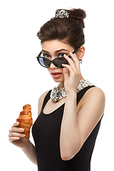 Image showing beautiful young woman in retro style with croissant