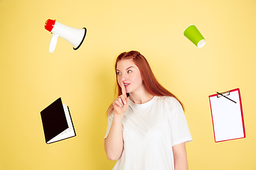 Image showing Caucasian young woman\'s portrait on yellow background, too much tasks