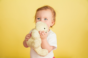 Image showing Caucasian little girl, children isolated on yellow studio background