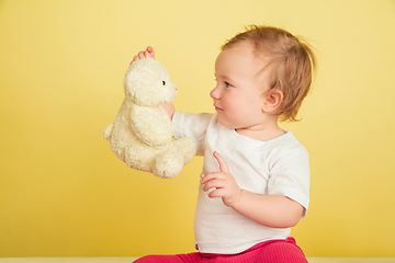 Image showing Caucasian little girl, children isolated on yellow studio background