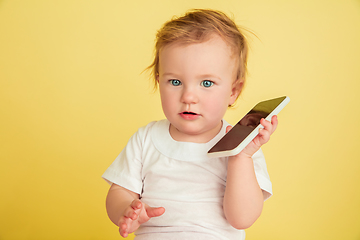 Image showing Caucasian little girl, children isolated on yellow studio background