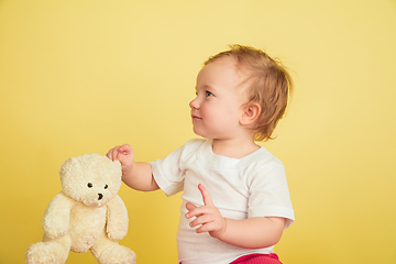 Image showing Caucasian little girl, children isolated on yellow studio background