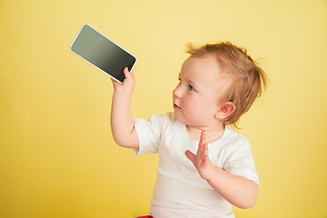 Image showing Caucasian little girl, children isolated on yellow studio background