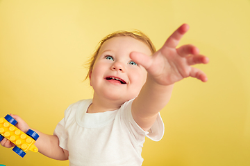 Image showing Caucasian little girl, children isolated on yellow studio background