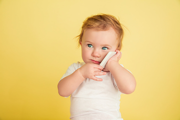 Image showing Caucasian little girl, children isolated on yellow studio background