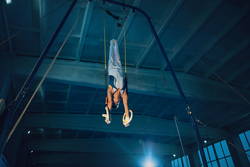 Image showing Little male gymnast training in gym, flexible and active