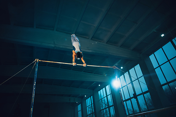 Image showing Little male gymnast training in gym, flexible and active