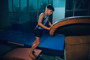 Image showing Little male gymnast training in gym, flexible and active