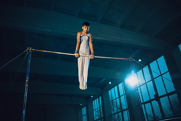 Image showing Little male gymnast training in gym, flexible and active