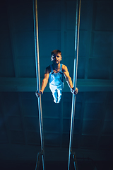 Image showing Little male gymnast training in gym, flexible and active