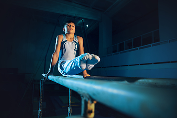 Image showing Little male gymnast training in gym, flexible and active