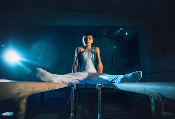 Image showing Little male gymnast training in gym, flexible and active