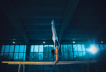 Image showing Little male gymnast training in gym, flexible and active