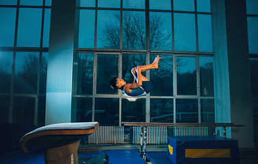 Image showing Little male gymnast training in gym, flexible and active