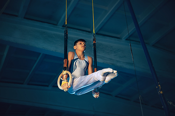 Image showing Little male gymnast training in gym, flexible and active