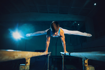 Image showing Little male gymnast training in gym, flexible and active