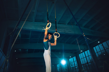 Image showing Little male gymnast training in gym, flexible and active