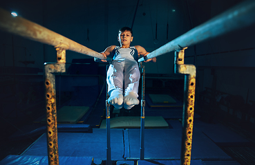 Image showing Little male gymnast training in gym, flexible and active