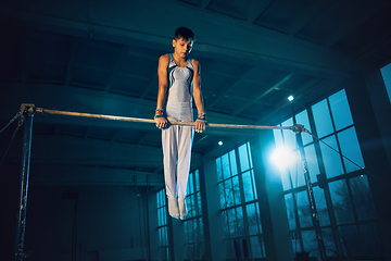 Image showing Little male gymnast training in gym, flexible and active