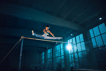 Image showing Little male gymnast training in gym, flexible and active