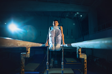 Image showing Little male gymnast training in gym, flexible and active