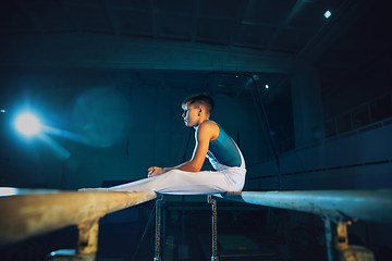 Image showing Little male gymnast training in gym, flexible and active