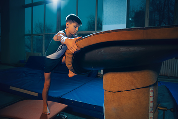 Image showing Little male gymnast training in gym, flexible and active