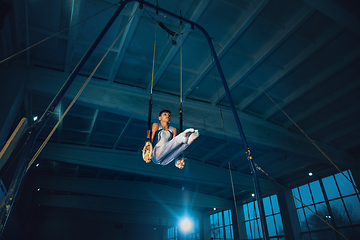 Image showing Little male gymnast training in gym, flexible and active