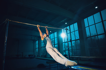 Image showing Little male gymnast training in gym, flexible and active