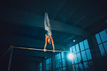 Image showing Little male gymnast training in gym, flexible and active