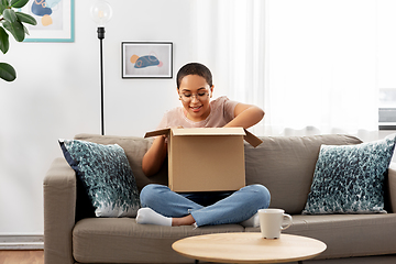 Image showing african american woman opening parcel box at home