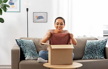 Image showing african american woman opening parcel box at home