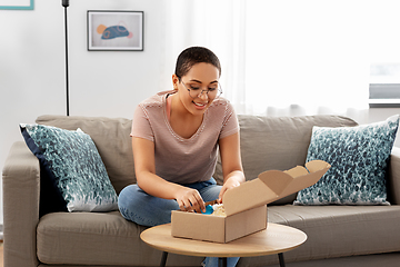 Image showing african american woman opening parcel box at home