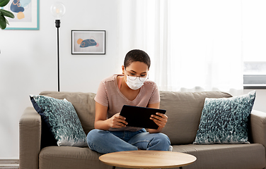 Image showing woman in medical mask with tablet pc at home