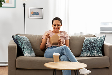 Image showing african woman eating food with chopsticks at home