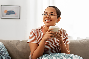 Image showing happy african woman drinking tea or coffee at home