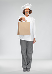 Image showing happy female chef with takeaway food in paper bag