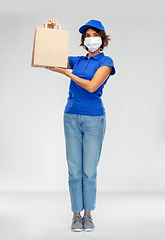 Image showing delivery woman in face mask with food in paper bag