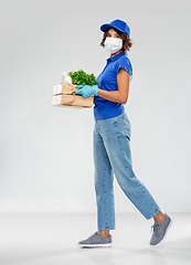 Image showing delivery woman in face mask with food in box