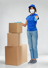 Image showing delivery woman in face mask with parcel boxes