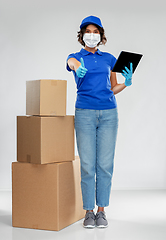 Image showing delivery woman in mask with boxes and tablet pc