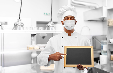 Image showing chef in face mask with chalkboard at kitchen