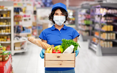 Image showing delivery girl in mask with food in box at store