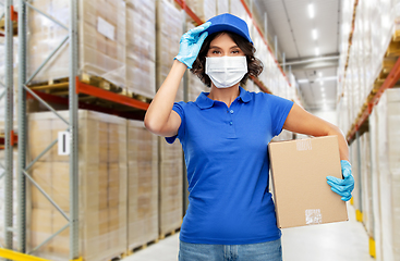 Image showing delivery woman in face mask holding parcel box