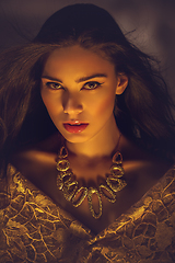 Image showing beautiful young woman with necklace in golden light