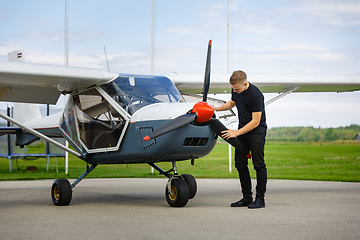 Image showing young man in small plane cockpit outdoors