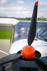 Image showing young man in small plane cockpit outdoors