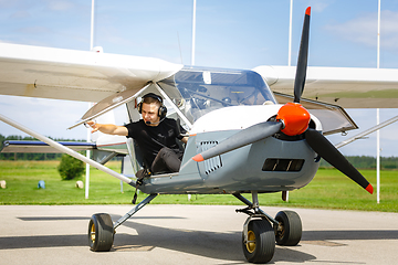 Image showing young man in small plane cockpit outdoors