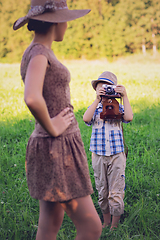 Image showing handsome little boy with retro camera and girl model